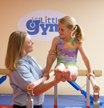 Child and instructor working on parallel bars