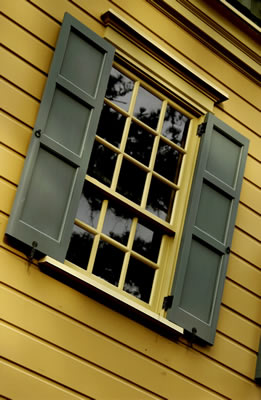 Yellow window green shutters